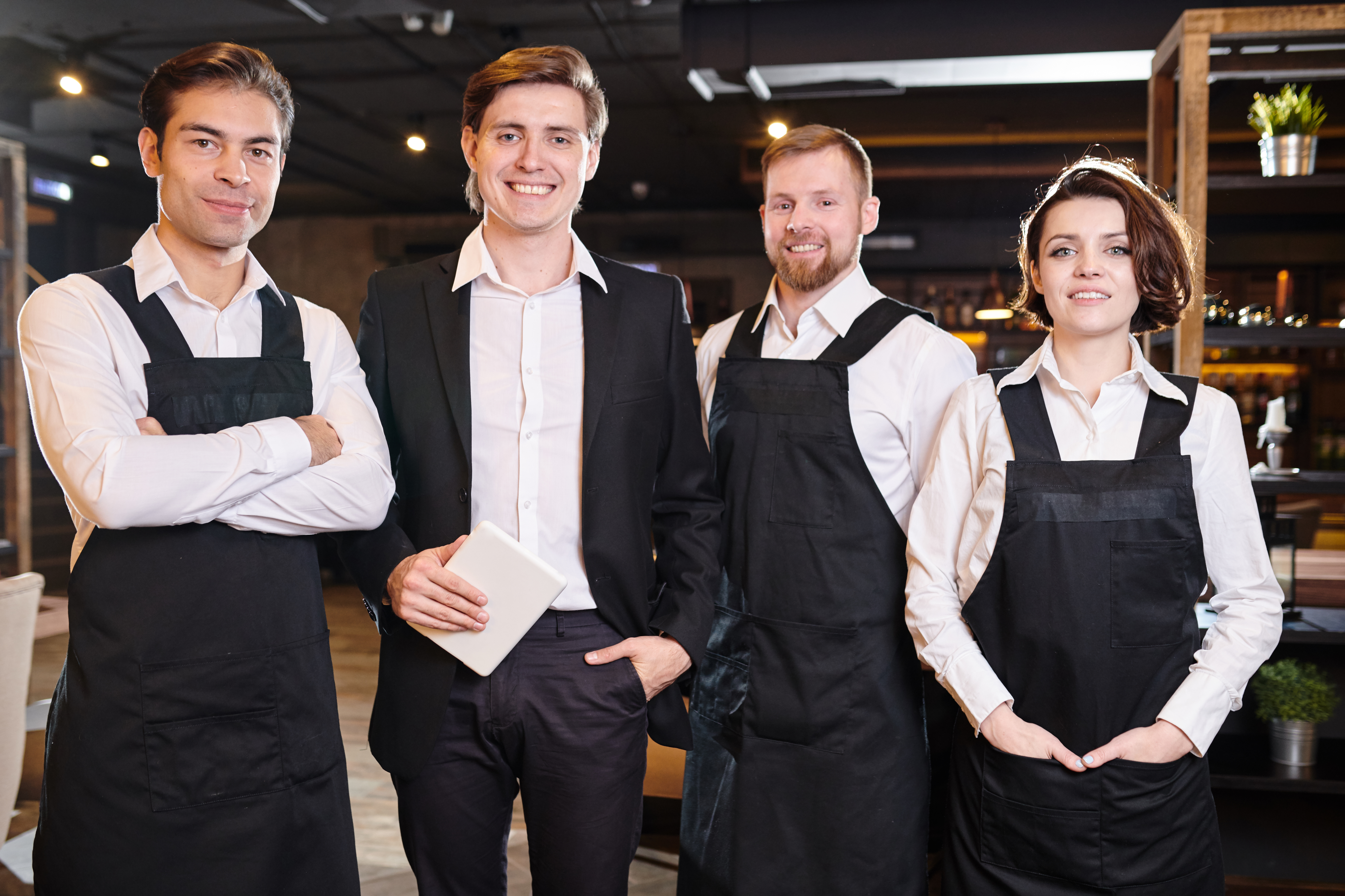 Équipe de restaurateurs en salle, illustrant les pratiques de service et la politique du restaurant concernant le doggy ba